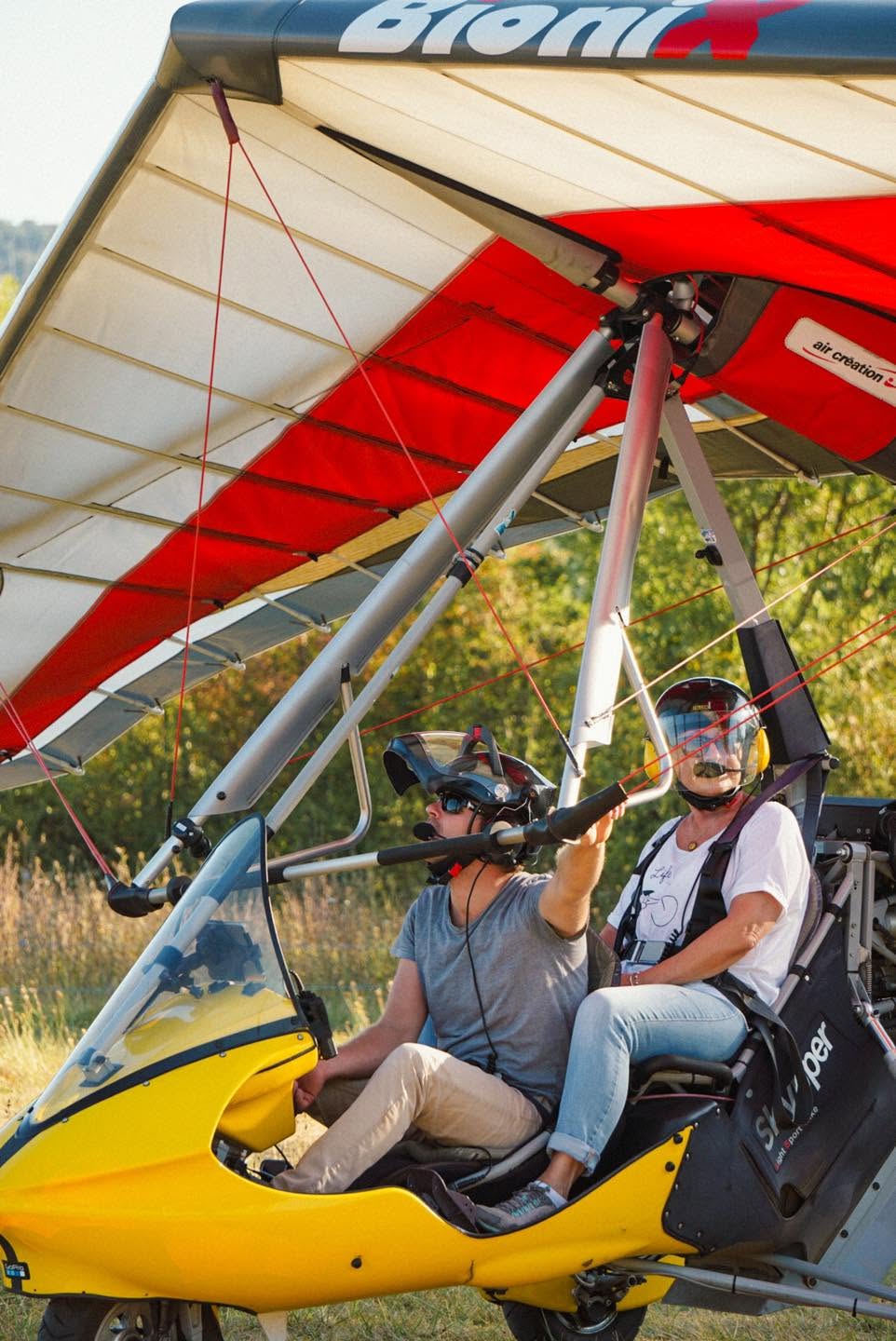 Passagère installée derrière le pilote dans un ULM pendulaire avant le décollage